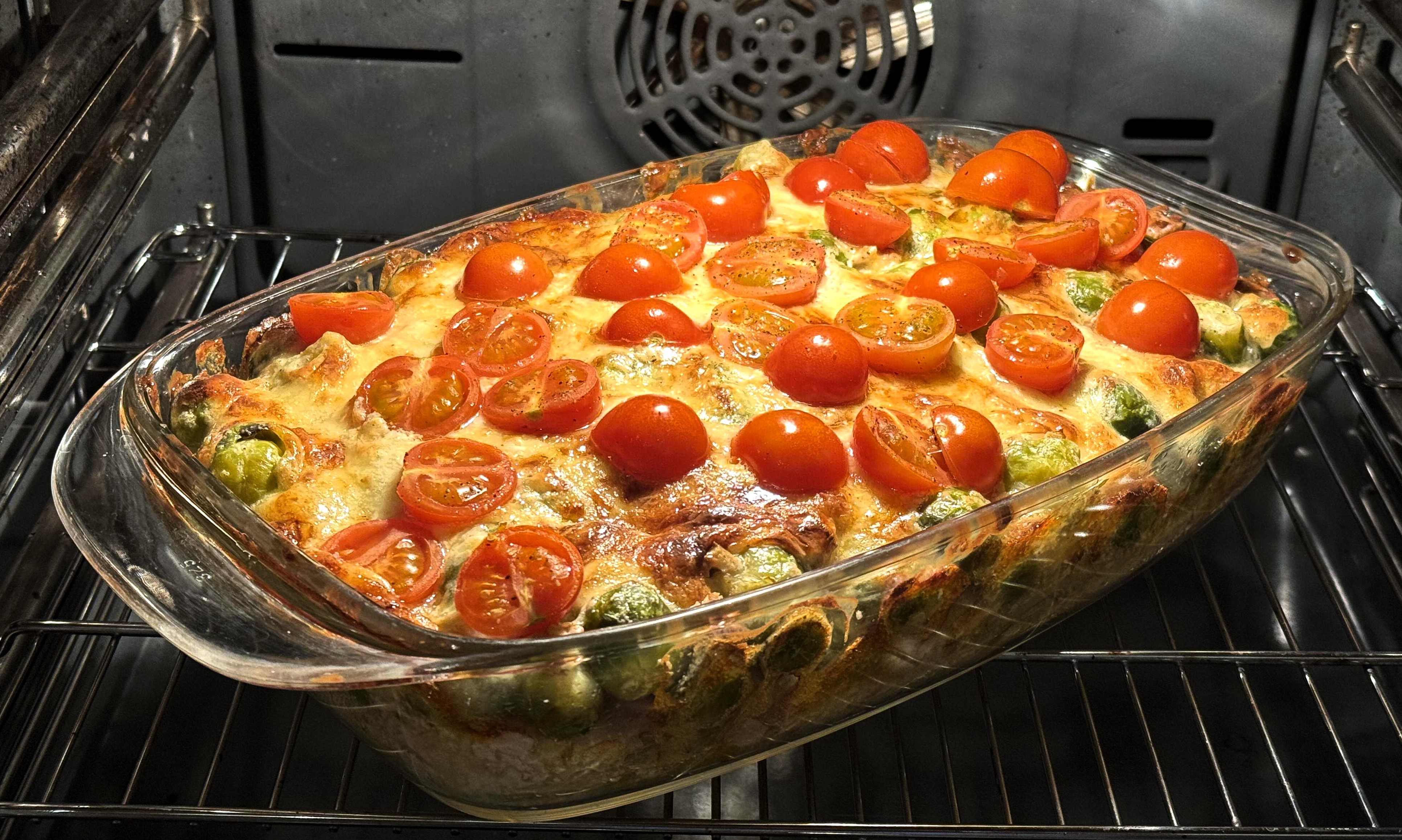 Die halbierten Tomaten werden später auf der Käseschicht verteilt und mitgebacken